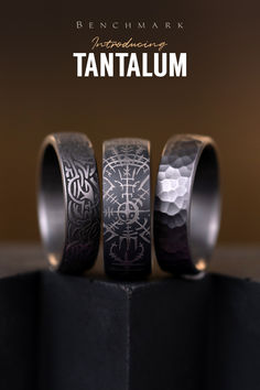 three rings are sitting on top of a black stand with the words tantalum printed on it