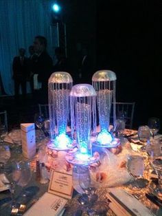 the table is set up for a formal dinner with blue and white lights on it