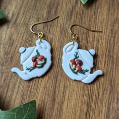 the teapot earrings are decorated with red and white flowers