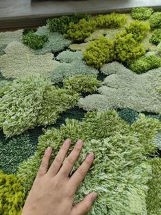 a person is touching the green carpet with their hand