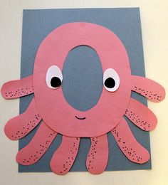 an octopus made out of construction paper on a white wall with eyes and nose drawn onto it