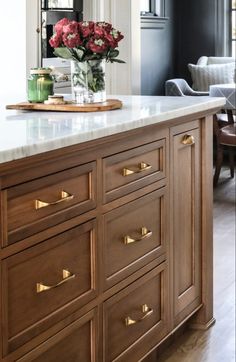 a kitchen island with marble top and gold handles