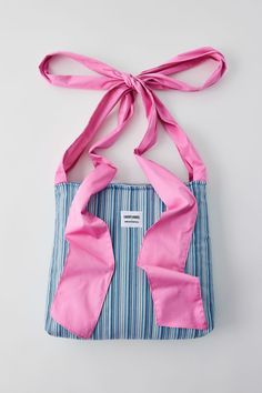 a blue and white striped bag with pink ribbon on the front, tied to it