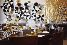 a black and white table setting with gold sequins on the wall behind it