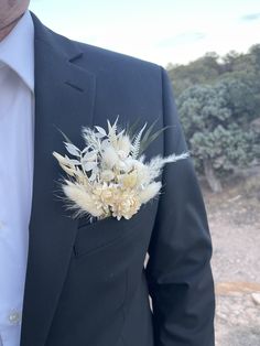 a man wearing a black suit and white flower boutonniere