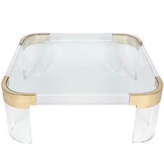 an acrylic coffee table with gold trimmings and clear glass, on a white background