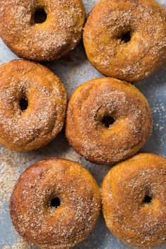 six sugared donuts on a blue surface