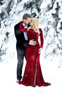 a man and woman are standing in the snow with their arms wrapped around each other