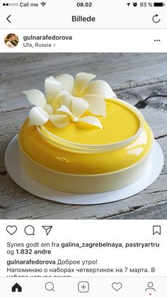 a yellow cake sitting on top of a wooden table next to an instagram page