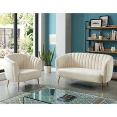 a living room with two chairs and a coffee table in front of a blue wall