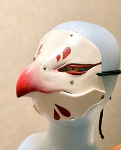 a close up of a mask on a mannequin's head with red and white paint