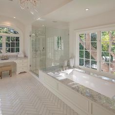 a large white bathroom with two sinks and a bathtub in the middle of it