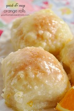 three orange rolls on a white plate with an orange slice next to it and the words quick & easy orange rolls