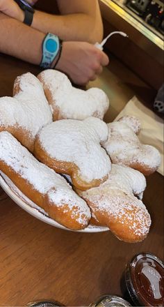 powdered sugar covered donuts on a white plate