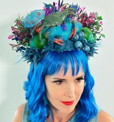 Step into a tropical paradise with our Handmade Decorated Tiki Hat. This unique accessory features a vibrant hat adorned with striking shells for festivals, beach parties, and Tiki-themed events, this hat combines style and comfort, ensuring you stand out and make a bold statement. Inspired by the exotic allure of Tiki culture, this decorated hat adds a festive and playful touch to any outfit. Whether you're dressing up for a special occasion or simply want to elevate your everyday style, this Tiki hat is the perfect accessory. Key Features: 🌺 Handmade with premium materials 🌺 Unique combination of vibrant flowers, decorative bananas 🌺 Comfortable and secure fit for all-day wear 🌺 Perfect for festivals, beach parties, and tiki-themed events 🌺 Adds a touch of seaside charm to any outfi Whimsical Costume Accessories For Carnival, Blue Whimsical Costume Hats And Headpieces, Fun Halloween Headpieces For Costume Party, Whimsical Blue Costume Hats And Headpieces For Festival, Themed Blue Costume Hats And Headpieces, Handmade Costume Hats And Headpieces For Costume Party, Blue Costume Hat For Carnival, Whimsical Costume Hats For Carnival And Halloween, Whimsical Costume Hats And Headpieces For Carnival And Halloween