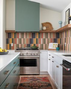 a kitchen with an oven, dishwasher and rug on the floor in front of it