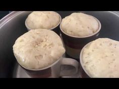 four mugs filled with food sitting on top of a stove