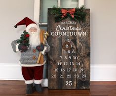 a santa clause holding a christmas tree next to a wooden sign with numbers on it