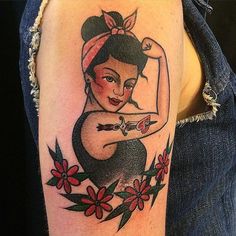 a woman's arm with a tattoo on it that has a pin up girl holding scissors