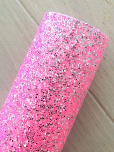 pink and silver glitter paper on a wooden surface