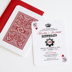 a red and white playing card next to a red envelope