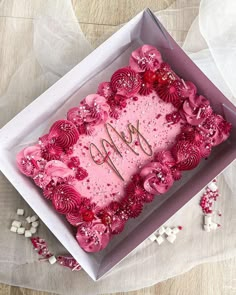 a pink birthday cake in a box on a table