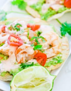 shrimp and avocado pita sandwich with lime wedges on the side for garnish