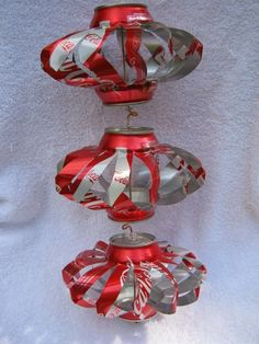 three red and silver vases sitting on top of a white cloth covered tablecloth