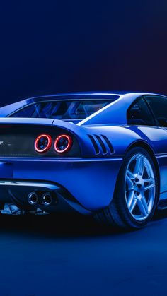 a blue sports car with its lights on