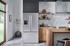 a modern kitchen with stainless steel appliances and wood cabinets, along with an open floor plan