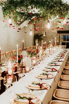 a long table is set with candles, plates and place settings for christmas dinner guests