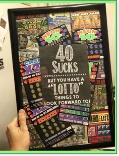 a person holding up a framed poster with the words 40 sucks but you have a lot of things to look forward to