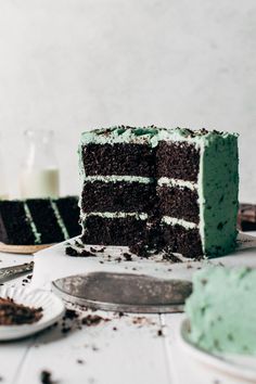 a slice of mint chocolate chip cake on a plate with the rest of the cake in the background