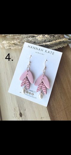 the earrings are pink with white pearls on them and one is shaped like a flower