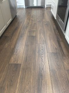 a kitchen with wood flooring and stainless steel appliances