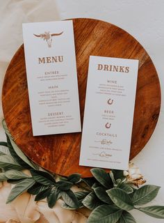 two menu cards sitting on top of a wooden plate