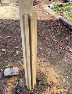 two wooden posts are standing in the dirt