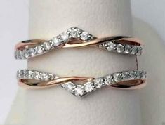 two wedding rings on top of each other, with diamonds in the middle and bottom