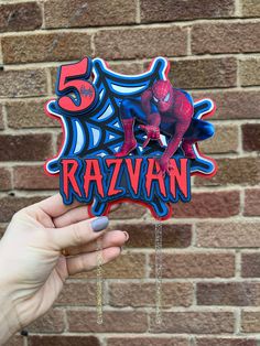 someone is holding up a magnet with the name razvan on it in front of a brick wall