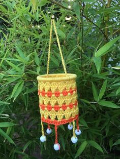 a crocheted pot holder hanging from a tree