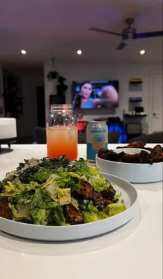 two white plates filled with food on top of a table next to a glass of orange juice