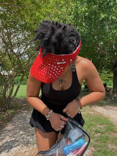 a woman wearing a red bandana and holding a clear bag