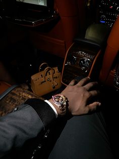 a man is sitting in the back seat of a car with his watch on his wrist