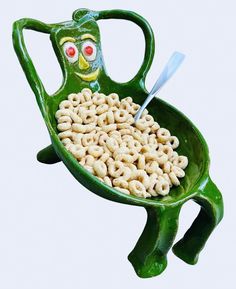 a green frog shaped bowl filled with cereal