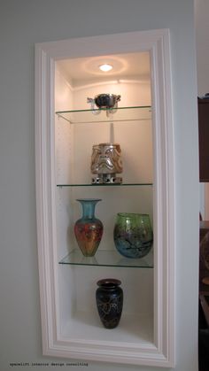 three vases are sitting on glass shelves in the corner