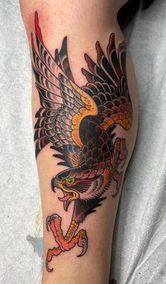 an eagle and snake tattoo on the leg