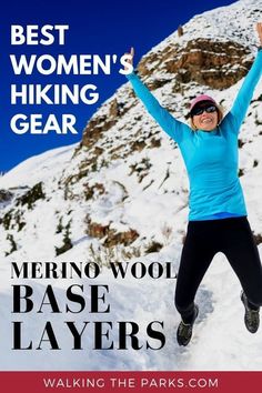 a woman jumping up in the air on top of a snow covered mountain with her arms outstretched