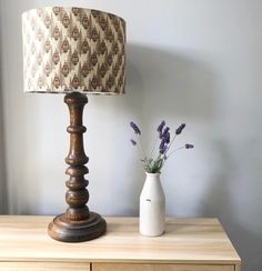 a table with a lamp and vase on it