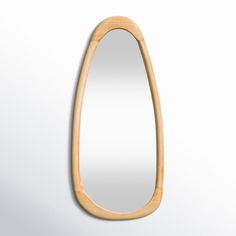 a wooden mirror hanging on the side of a wall with an oval shaped frame in front of it