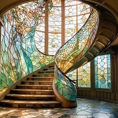 a spiral staircase with stained glass windows in the center and stairs leading up to it